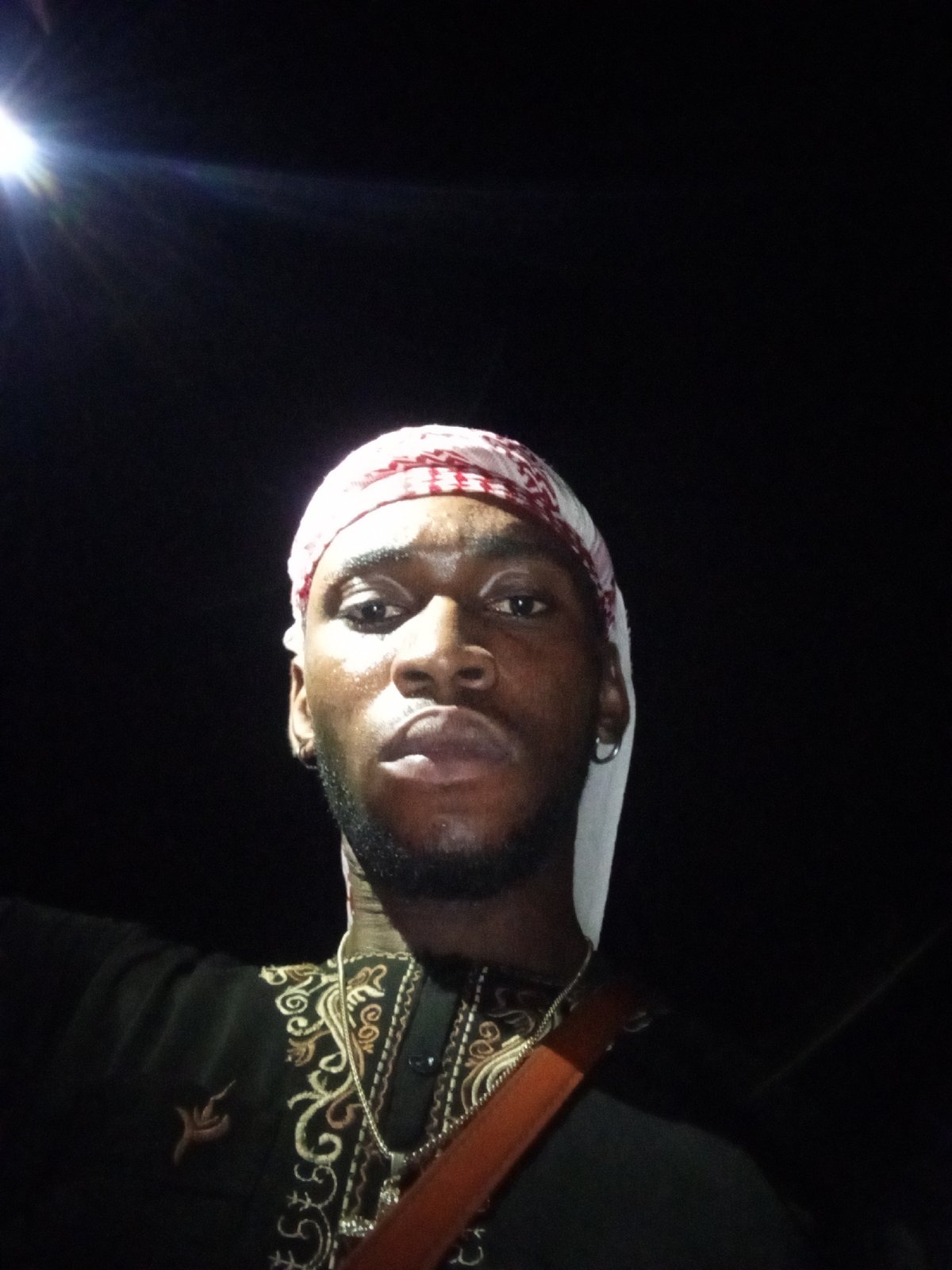 Man in traditional dress photographed at night in Lokoja