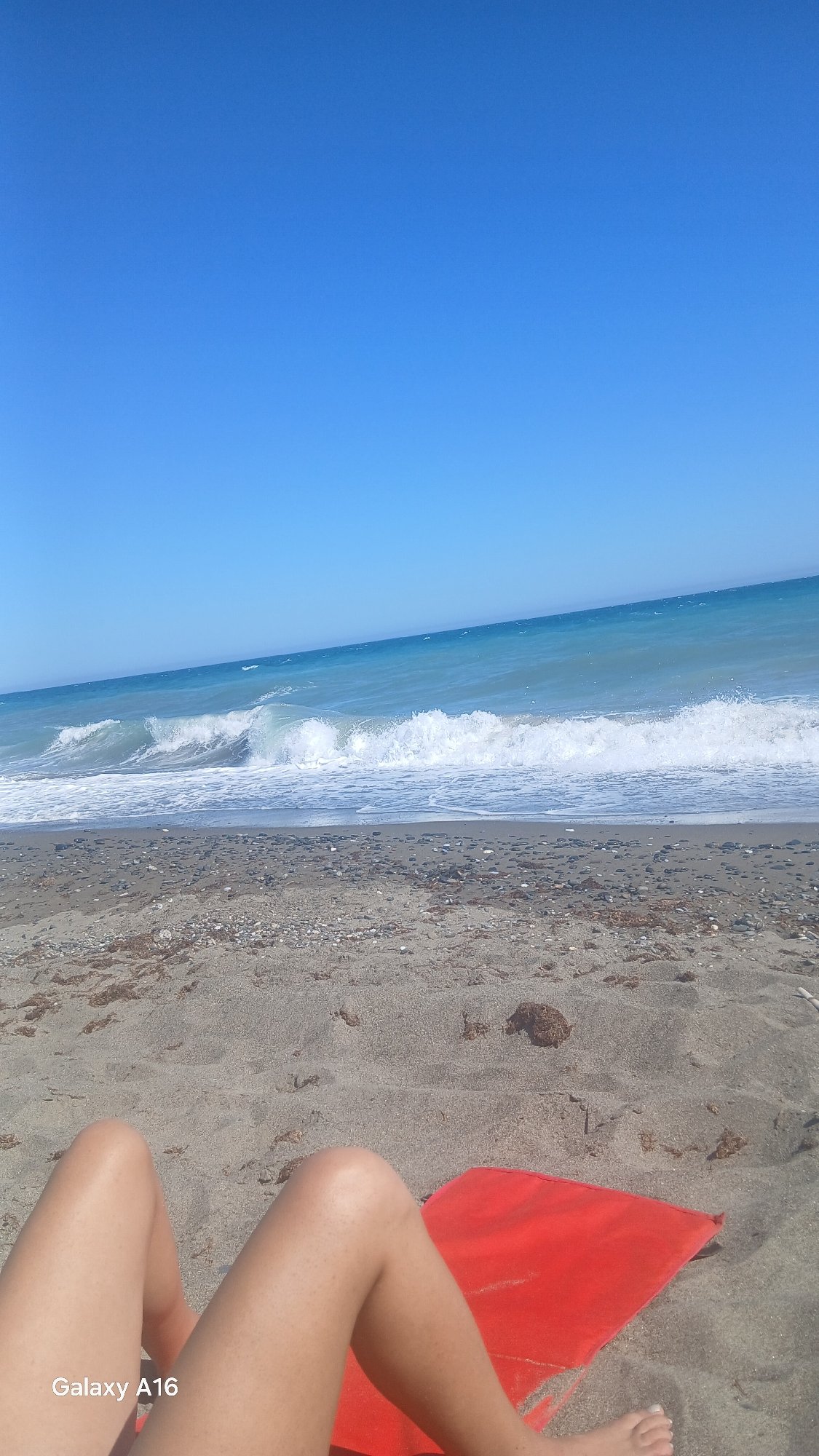 Sunny beach day with colorful umbrella and crashing waves