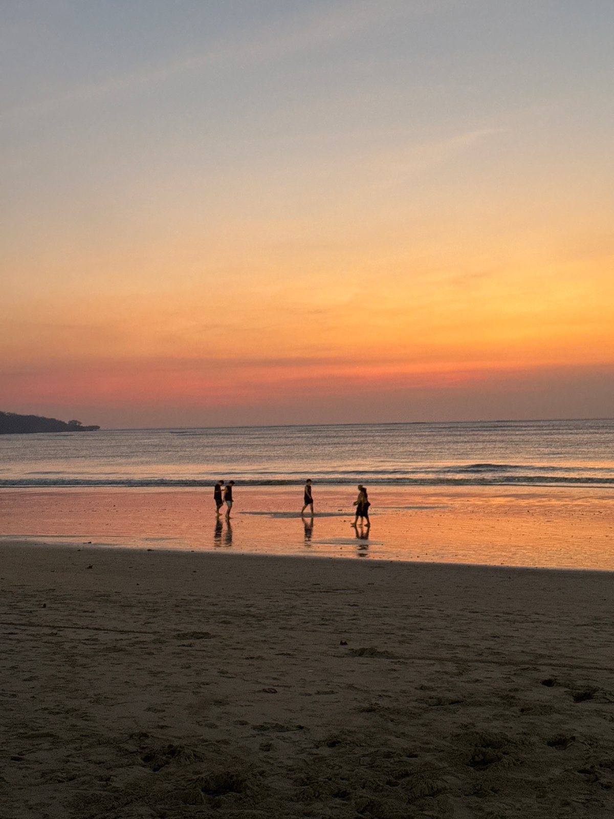 Golden hour at Kuta Beach, Bali — waves, silhouettes, sunset.