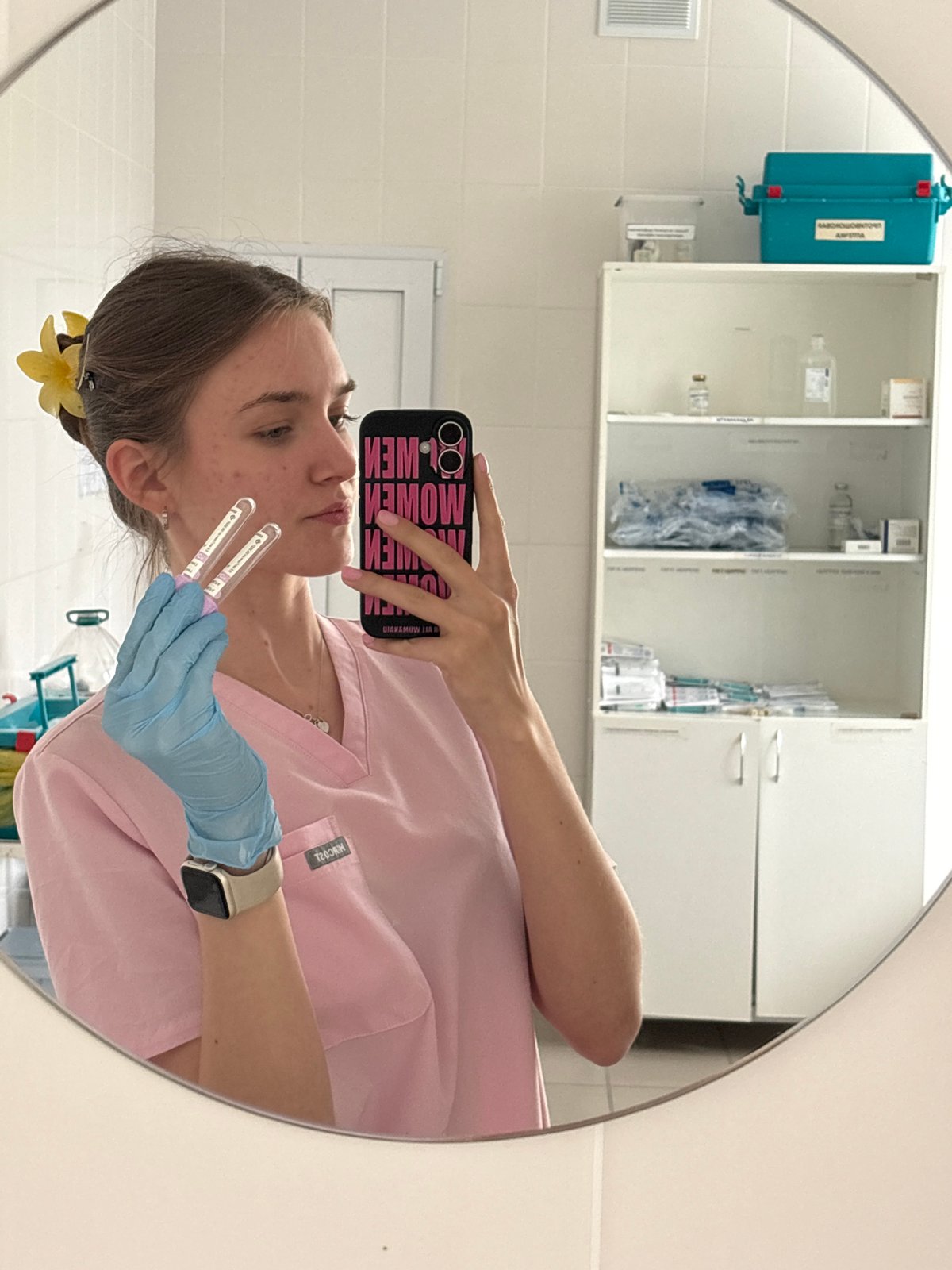 Healthcare worker takes mirror selfie in medical scrubs