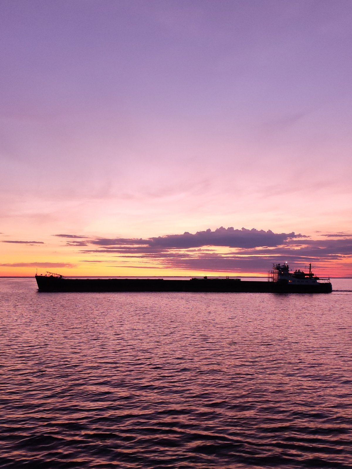 Barge crosses Russian waters during vibrant sunset display