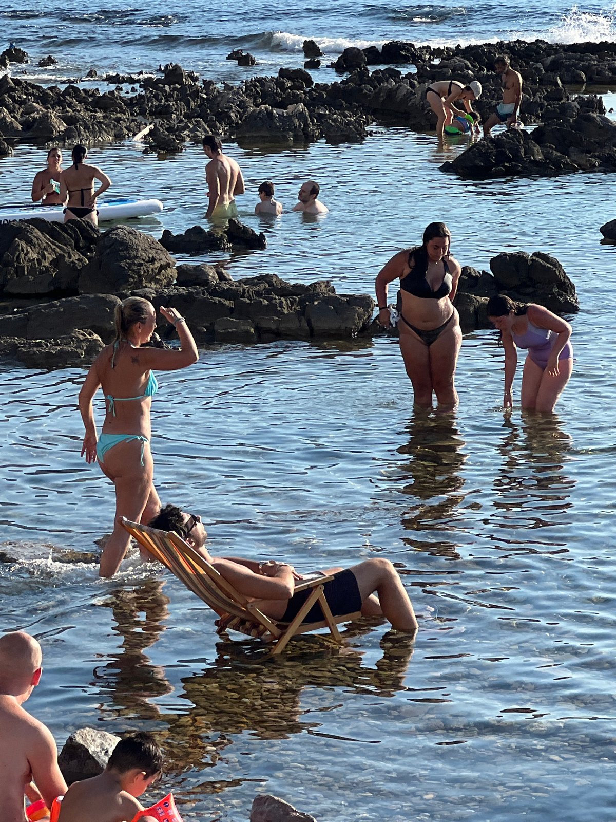 Deck chairs in the shallows at a Palermo rocky beach