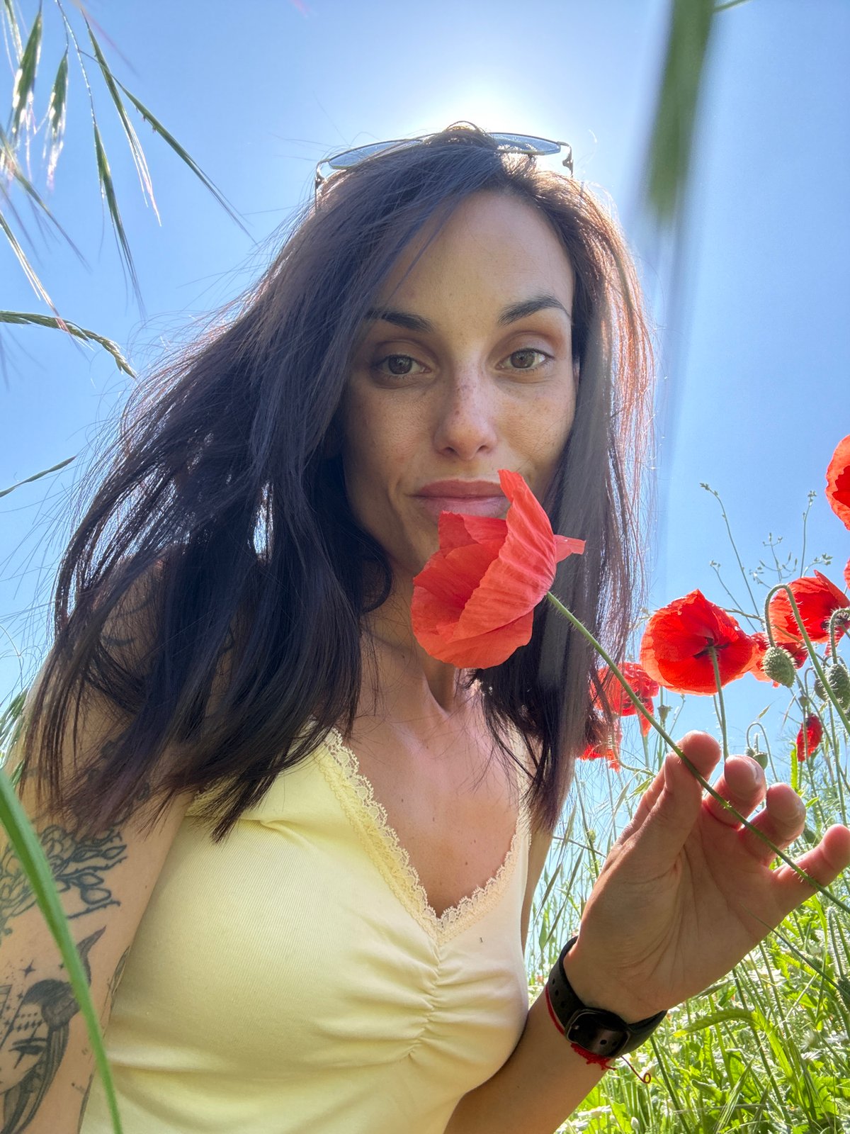 Woman photographs herself in poppy field near Pleven, Bulgaria