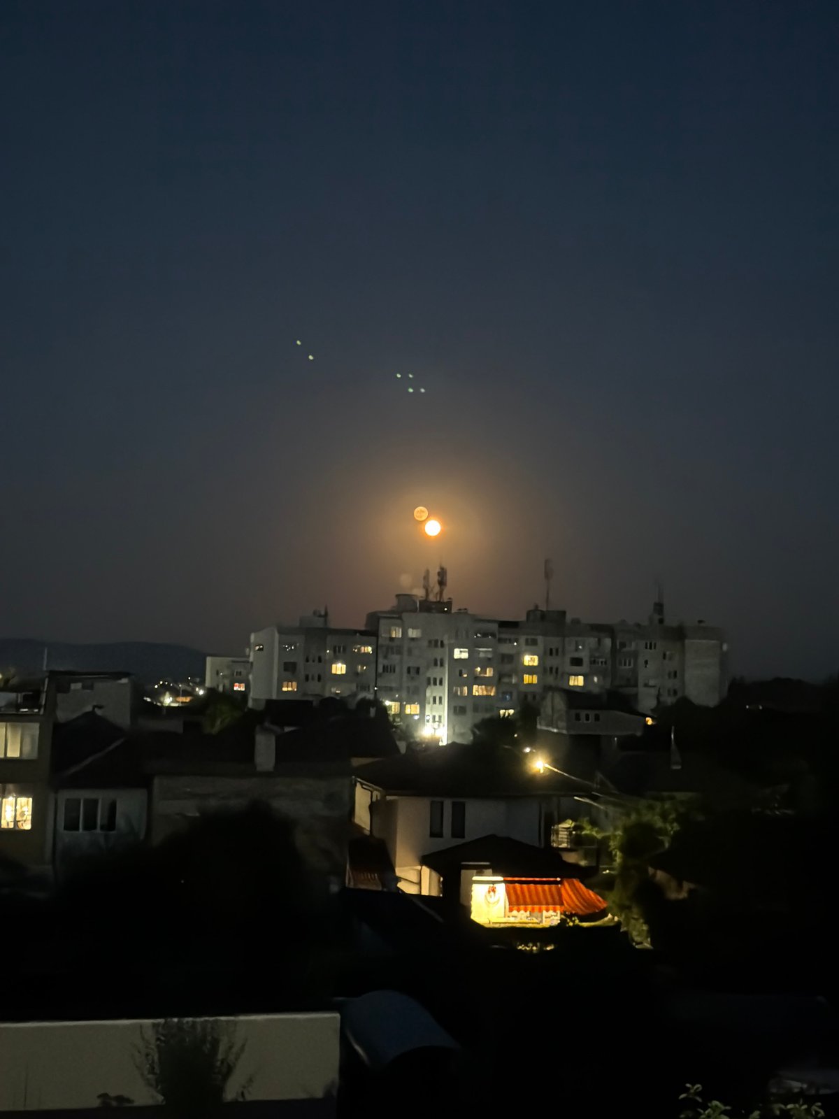 Bright orange moon rises over Burgas on a clear June night