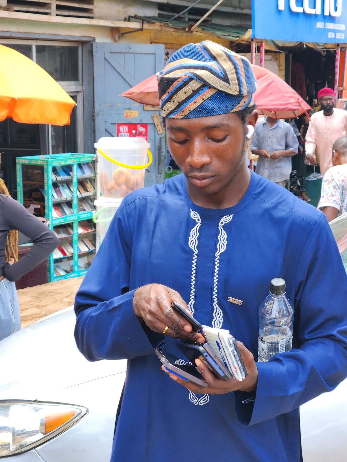 Street scene: phones, braided hair, and a weathered storefront