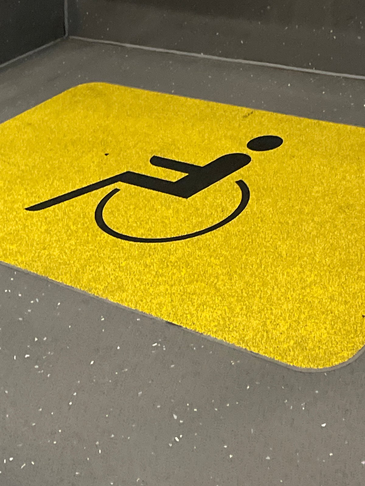 Accessibility sign documented on grey surface in Barcelona