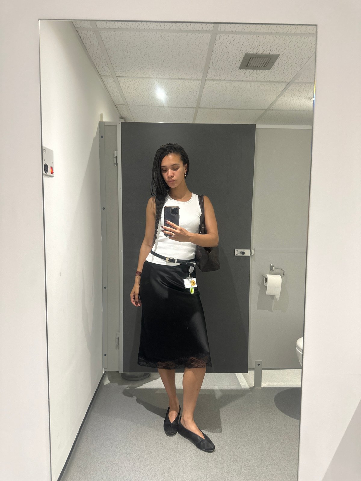 Woman takes mirror selfie in London bathroom stall