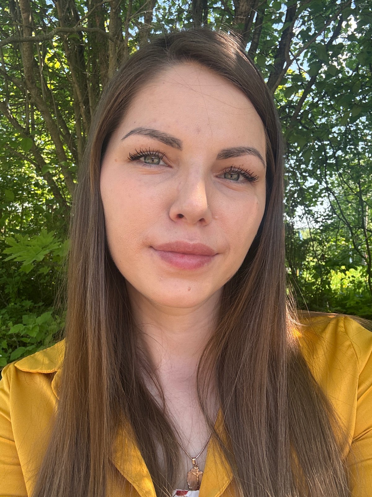 Woman takes outdoor selfies on sunny morning in Shevlyakovo