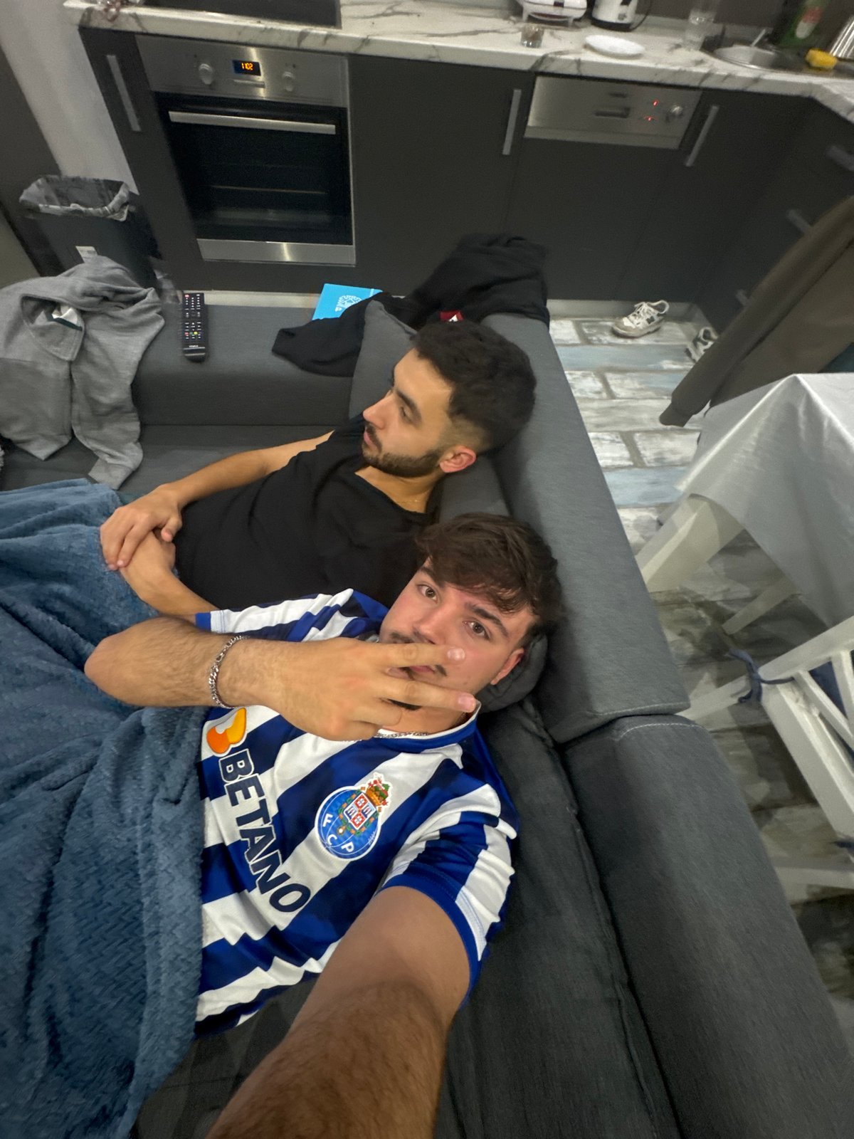Two men rest on sofa in Rijeka apartment