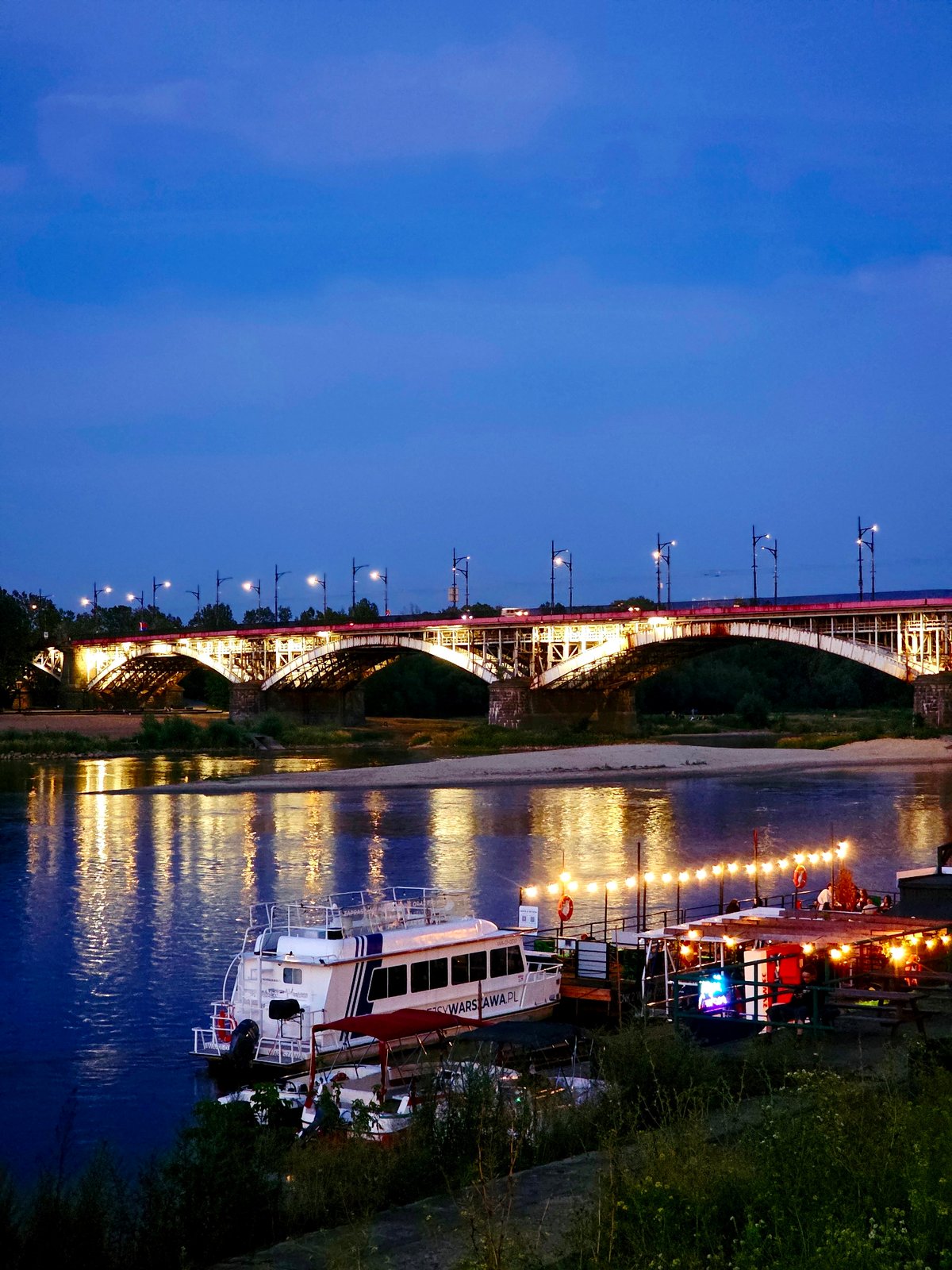 Warsaw's Vistula riverfront at golden hour into night