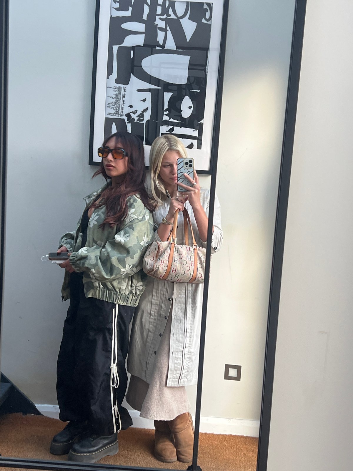 Two women captured in mirror reflection in London