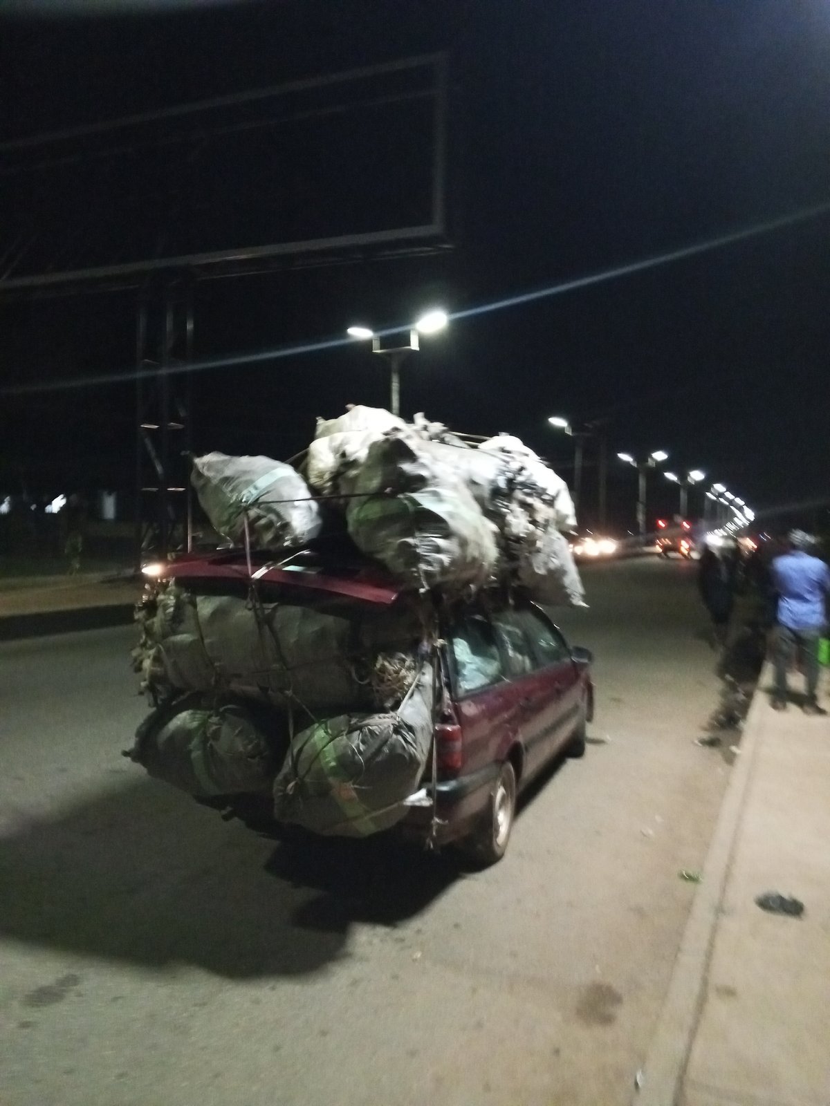 Heavy cargo transport, street vendors active during Bukuru evening hours