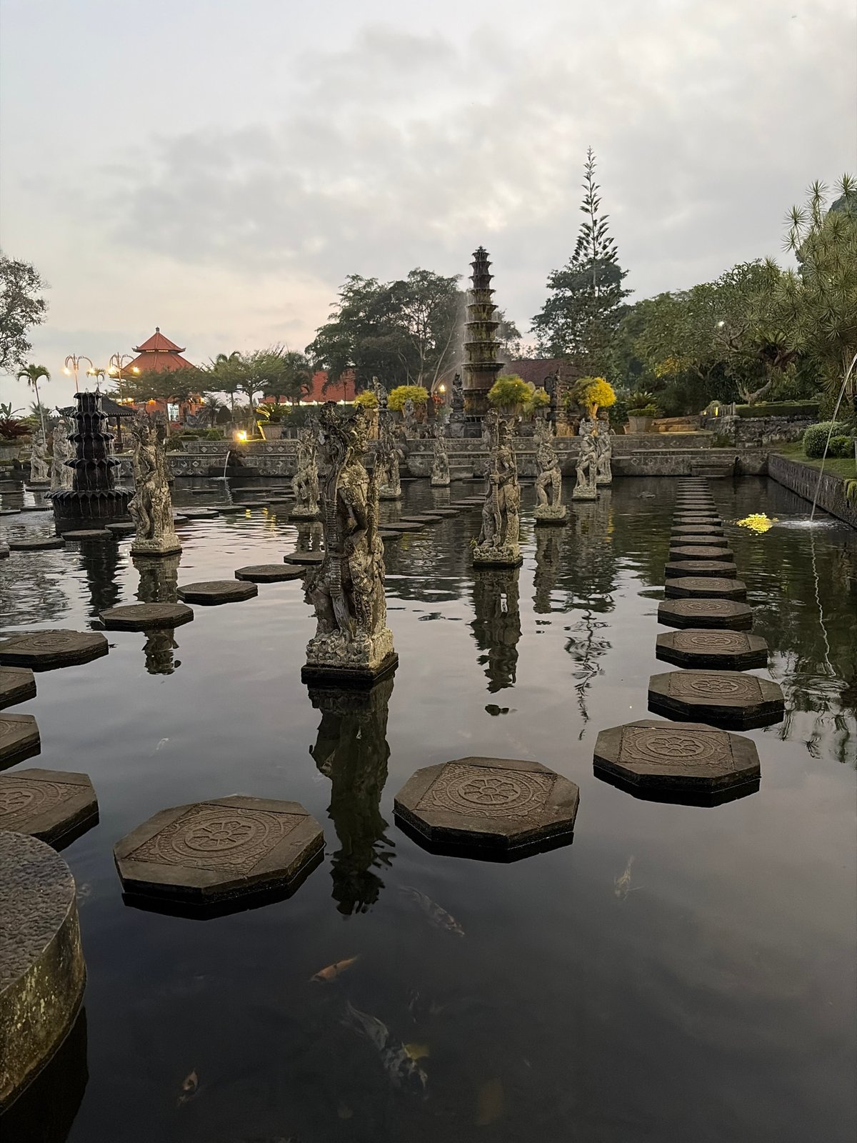 Tirta Gangga Water Palace: stepping stones and statues at dusk