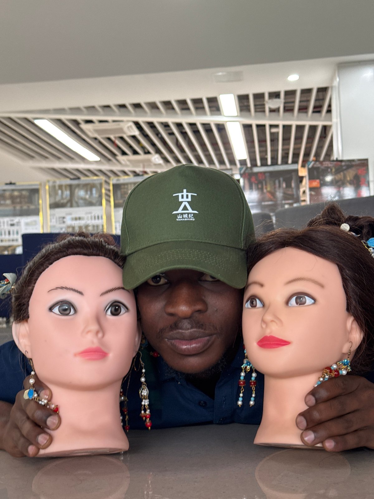 Posing with ornate mannequin heads at a Jiangjin retail space