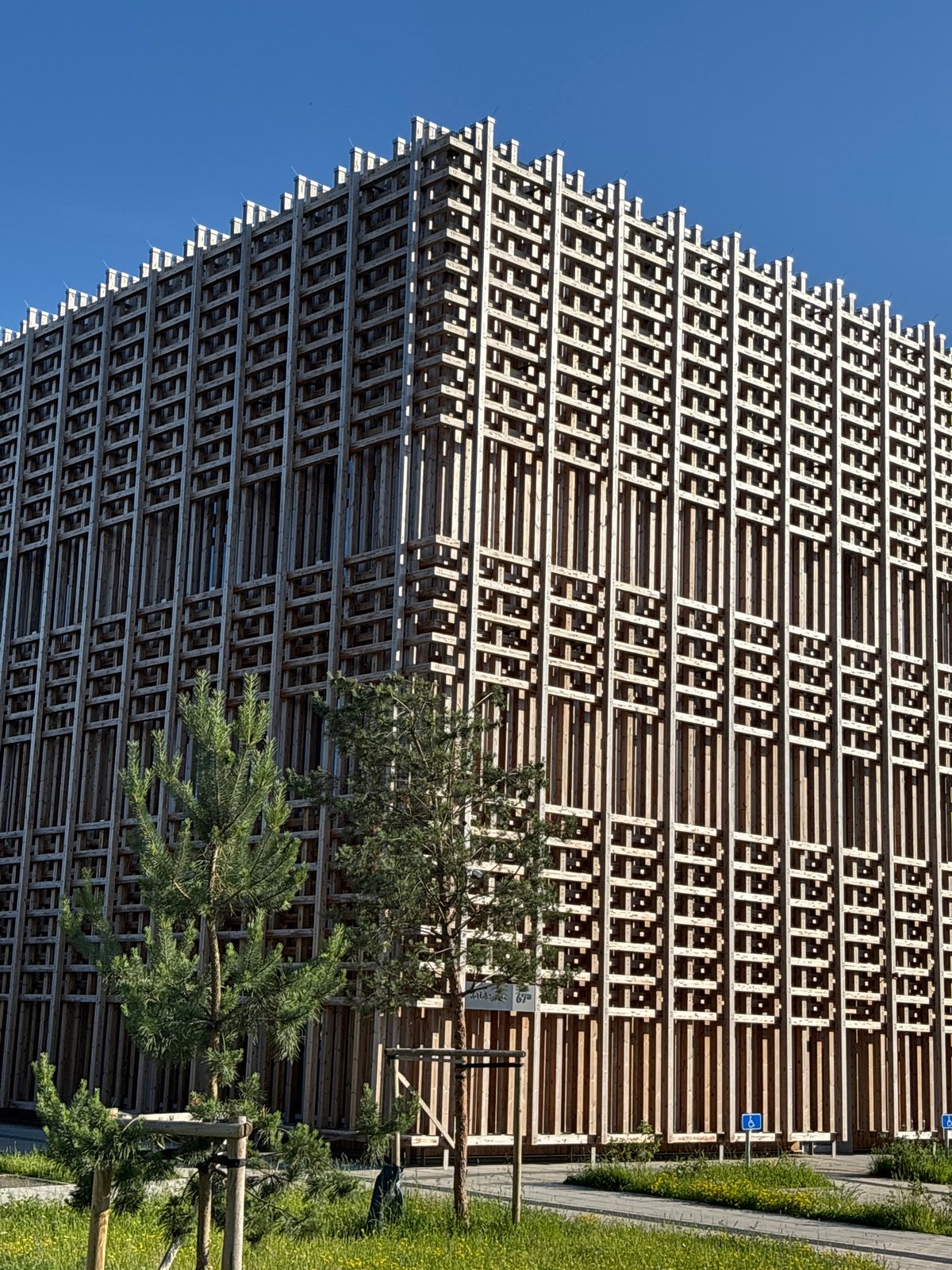Tallinn building with wooden lattice facade, pink shrubs in bloom