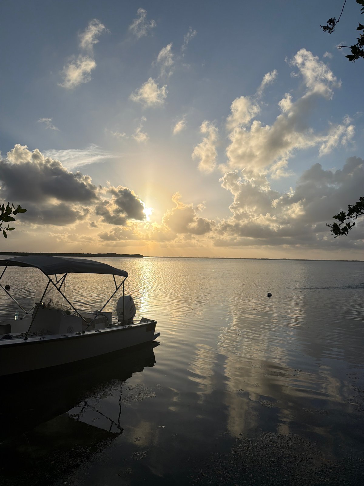 Sunset captured over Cancún waters with docked boat