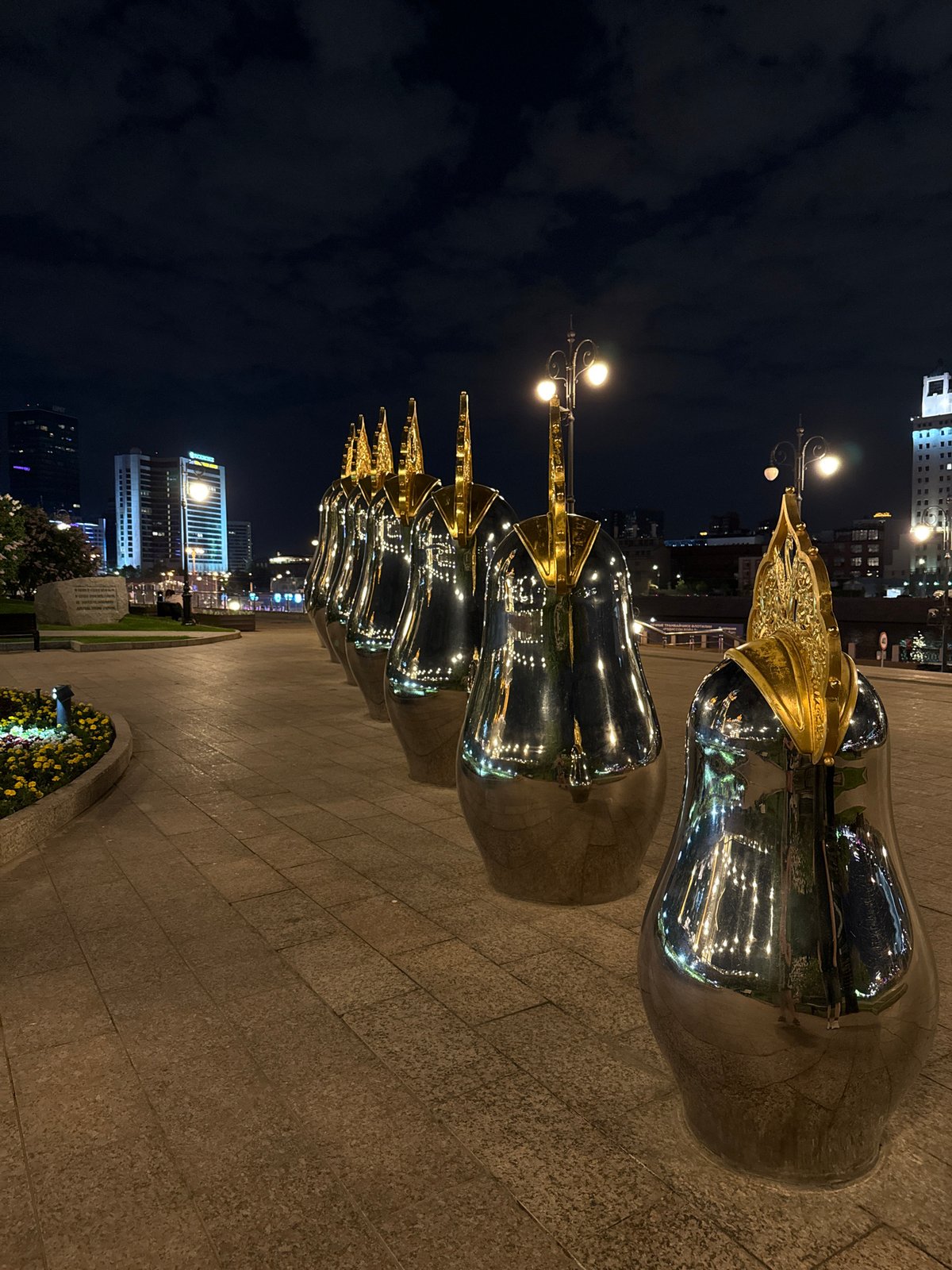 Ornamental mirrored sculptures documented along Moscow walkway at night