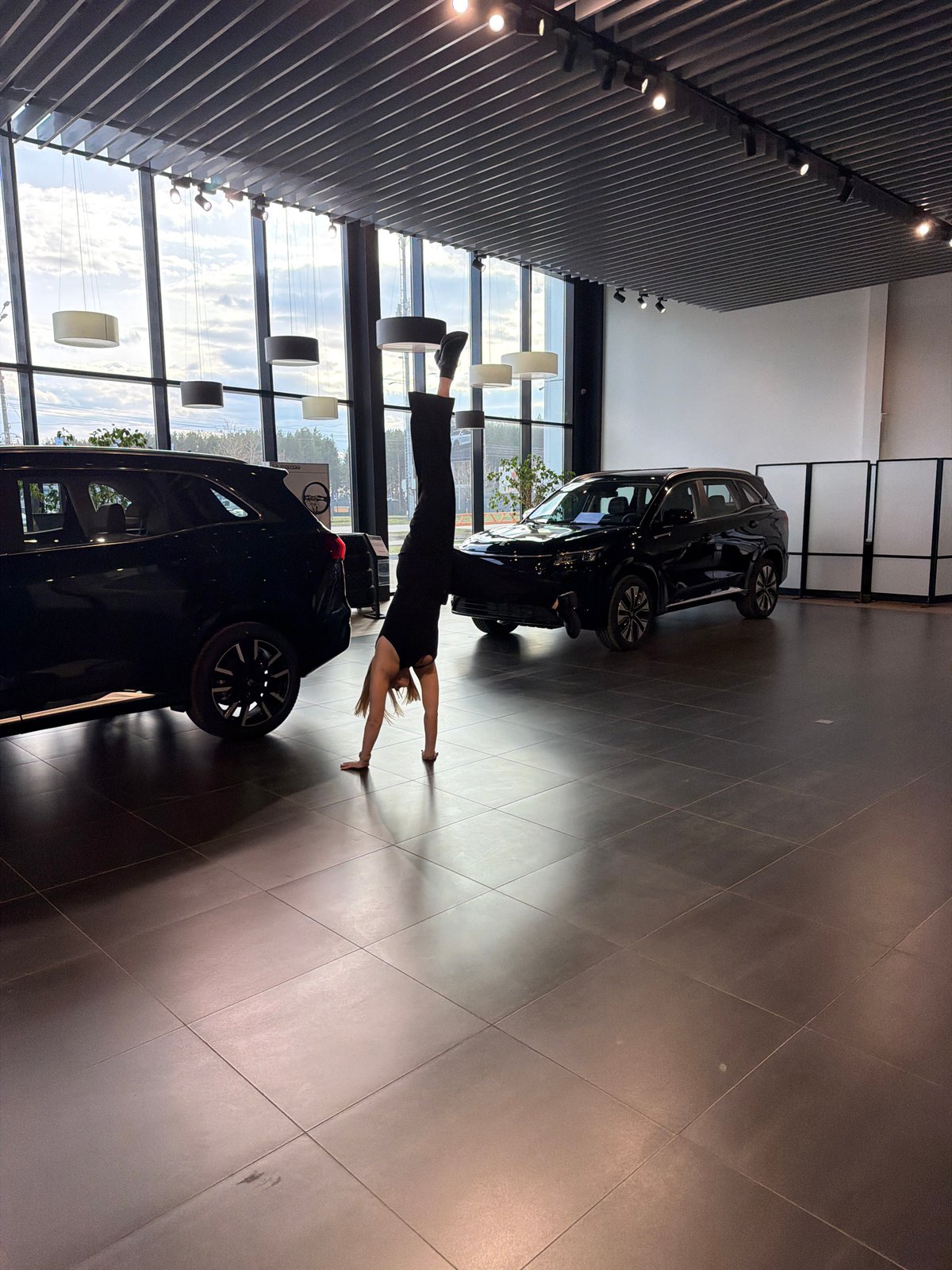 Woman performs gymnastics in Russian car dealership showroom
