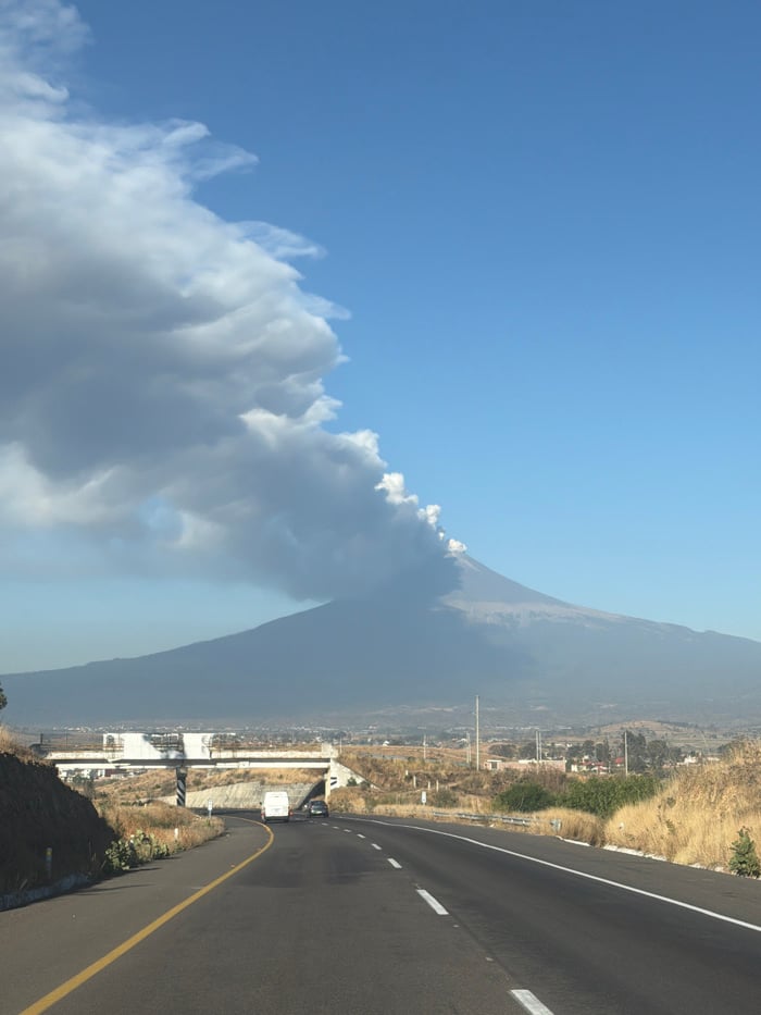 Volcano emits smoke near Mexican town, vehicles pass nearby