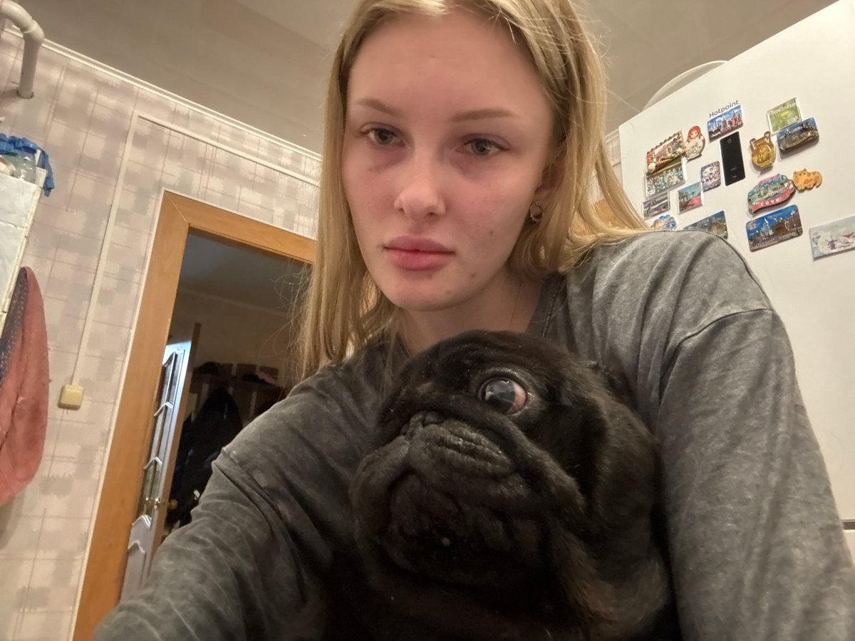 Woman plays with black pug dog in Бородулино home