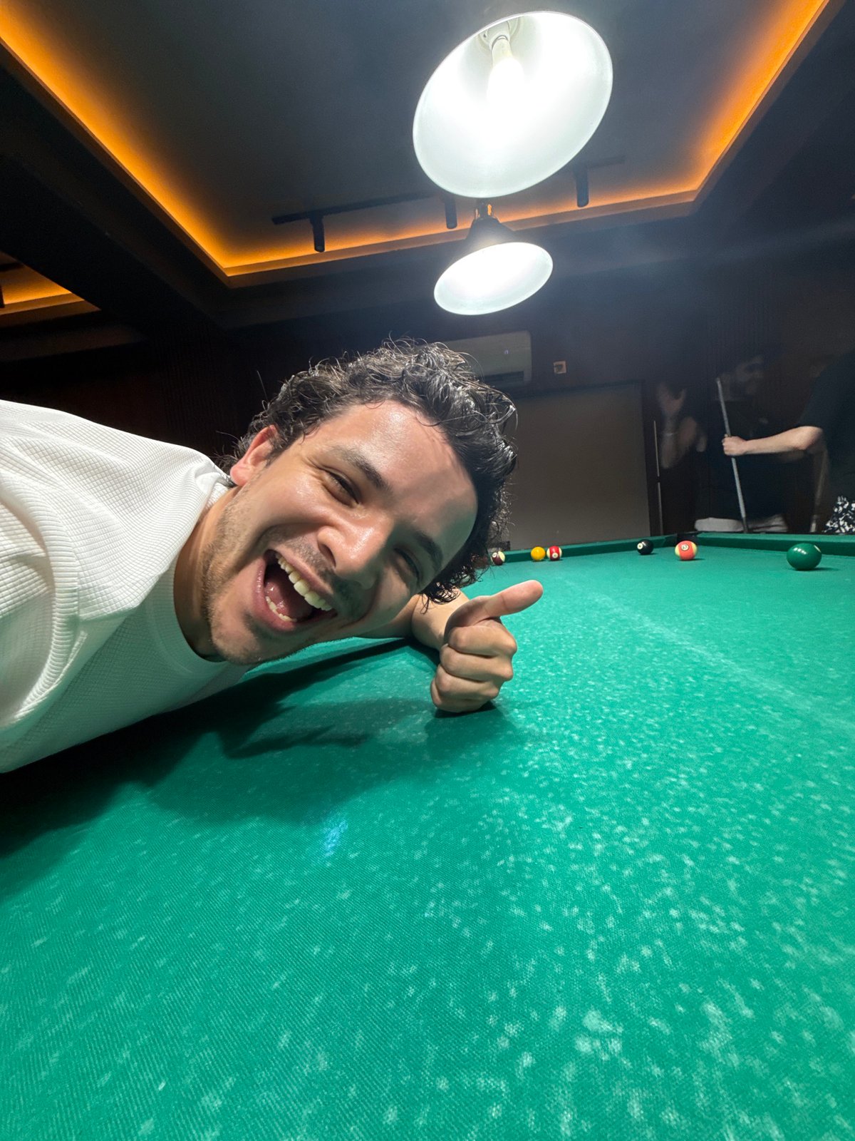 Man takes thumbs-up selfie at pool table in Tashkent