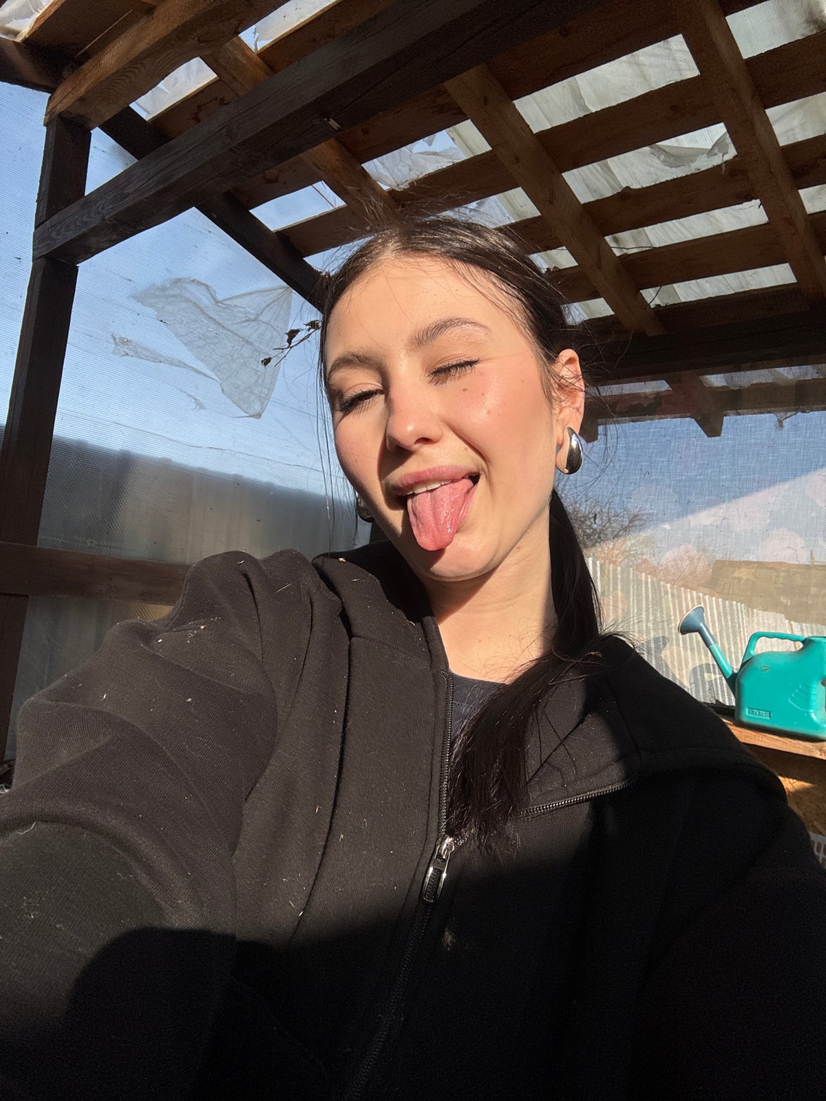 Woman makes playful face in makeshift structure near Фоки