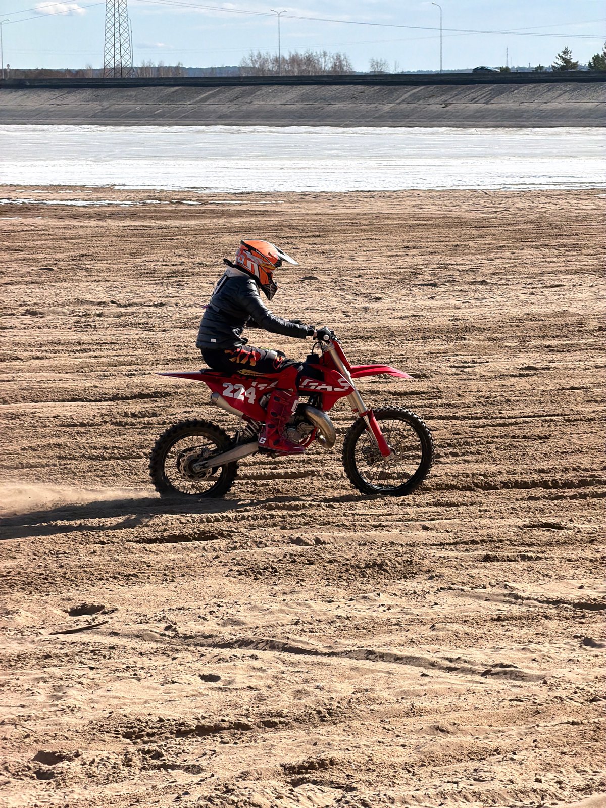 Motocross riders perform stunts near frozen river in Chaikovsky