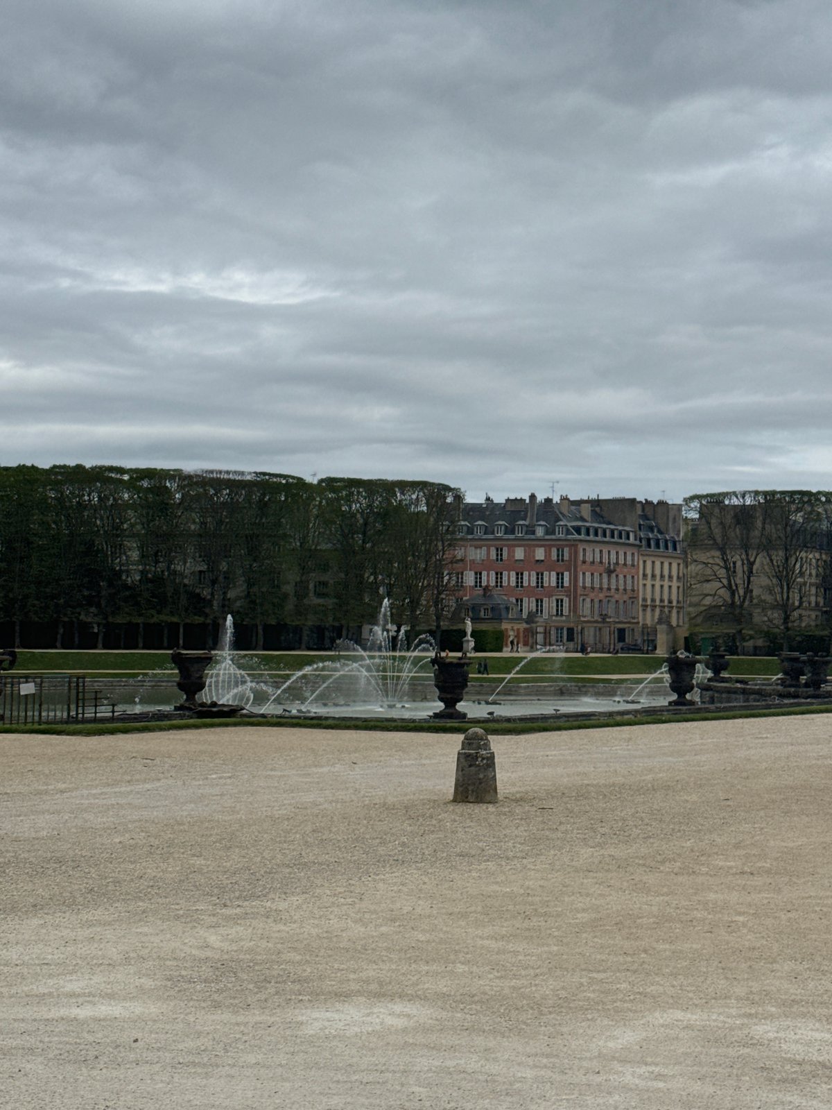 Tourist activity documented at Versailles attractions on overcast afternoon