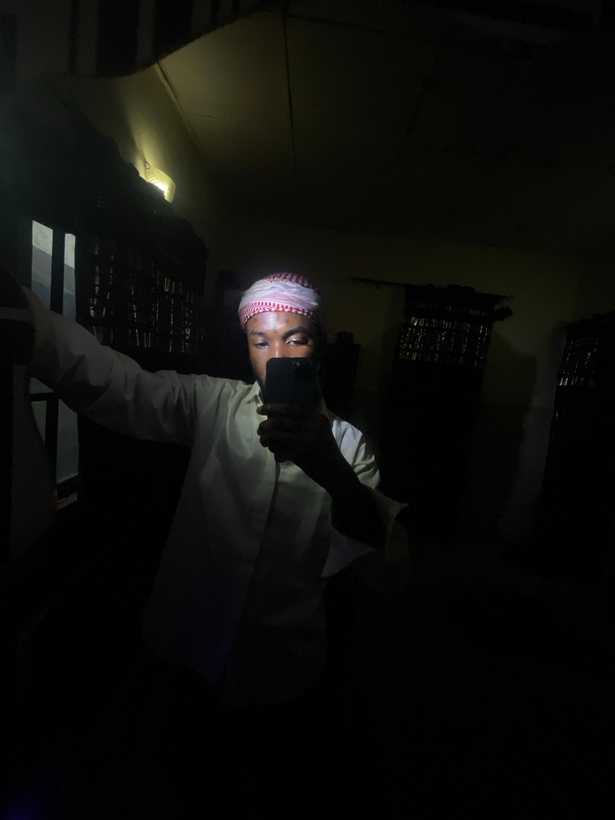 Man takes selfies in dimly lit room