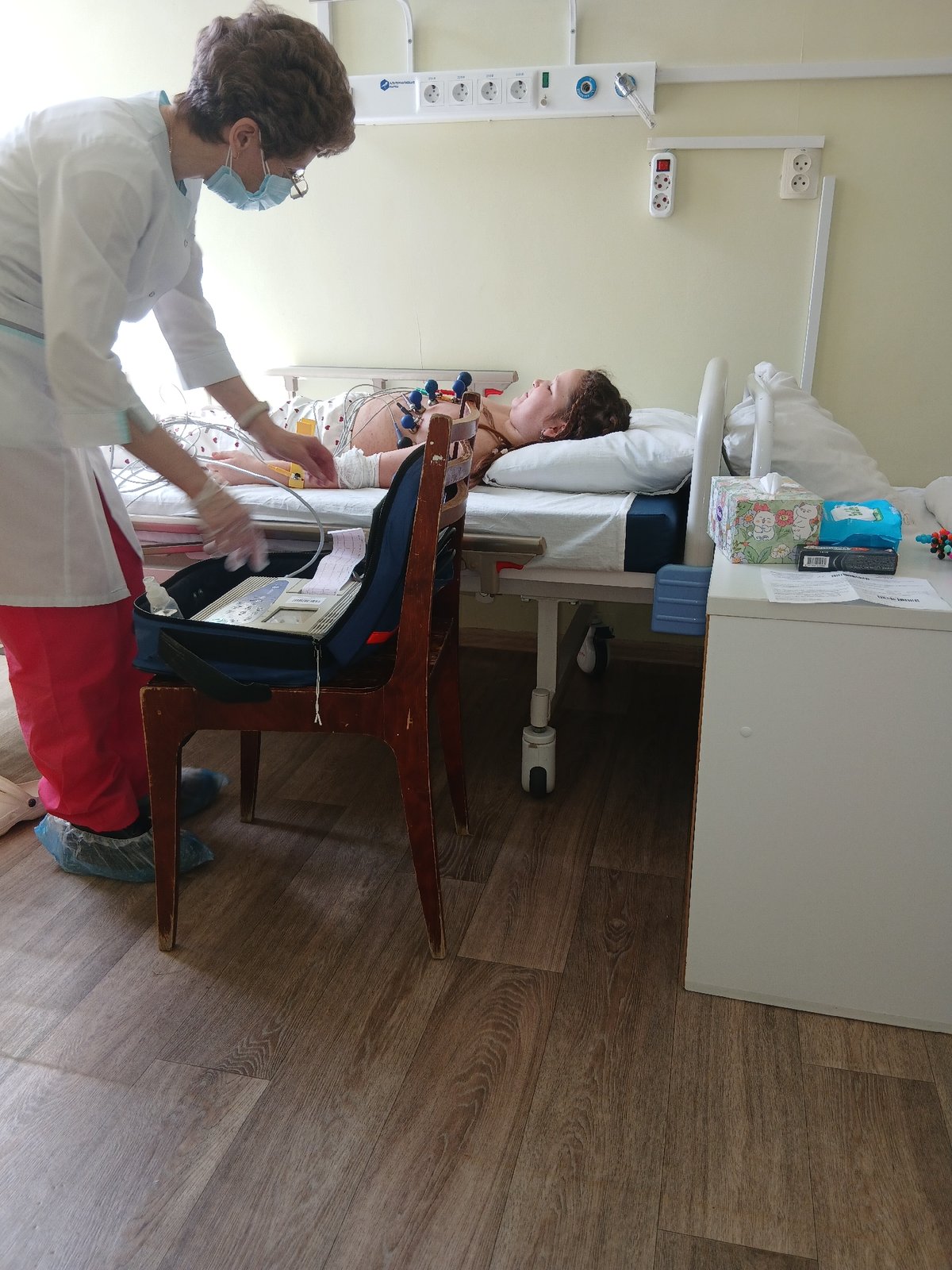 Medical staff attend young patient in hospital room
