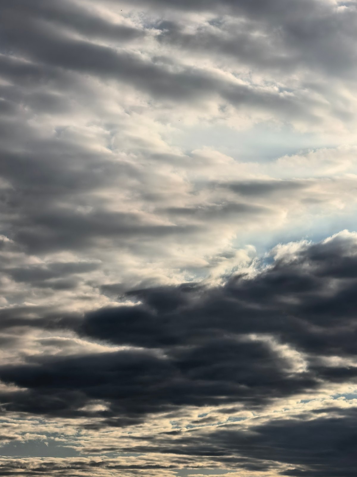 Sun pushing through heavy cloud cover, golden light on the edges