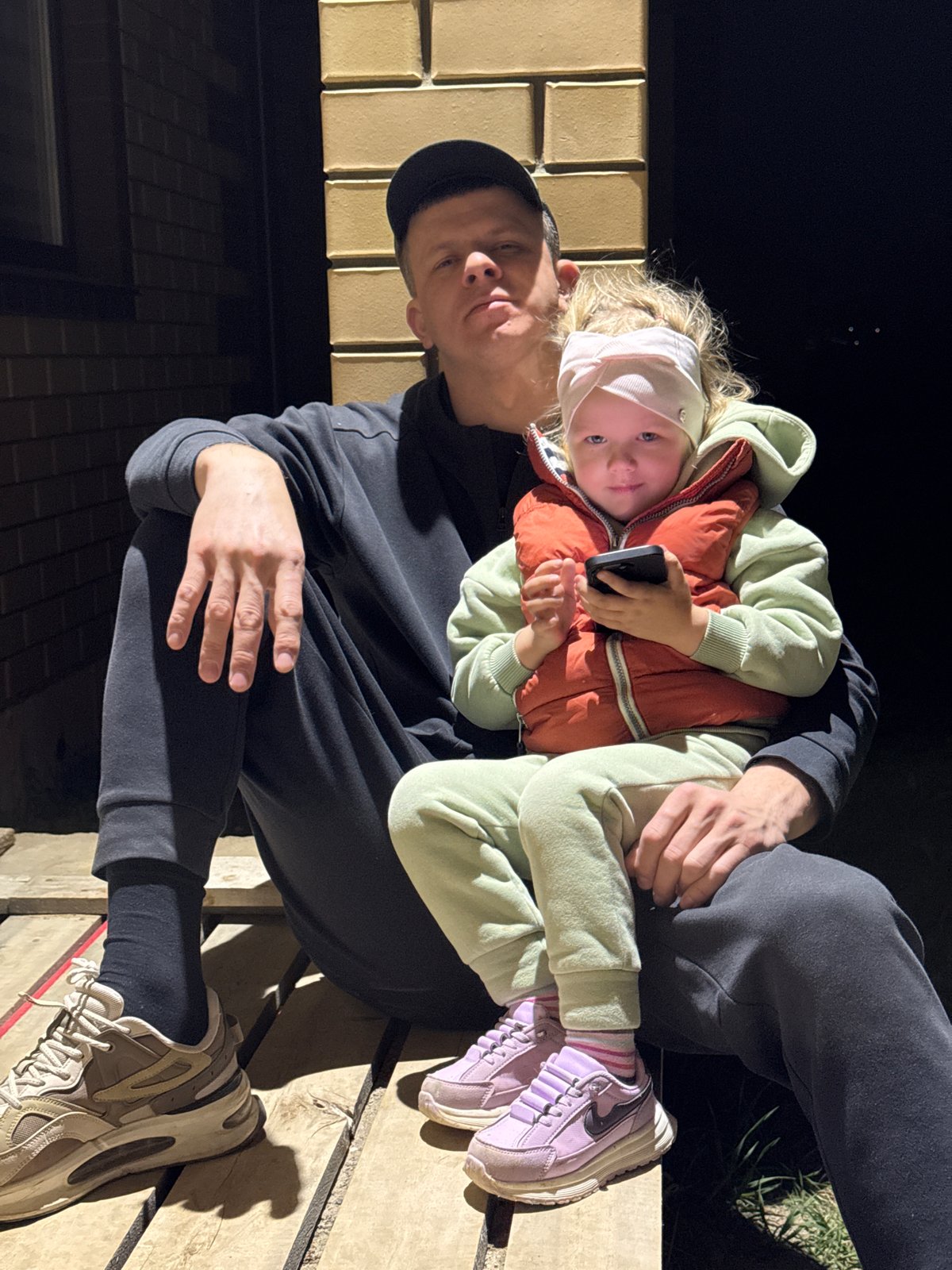Father and child share quiet moment on wooden structure