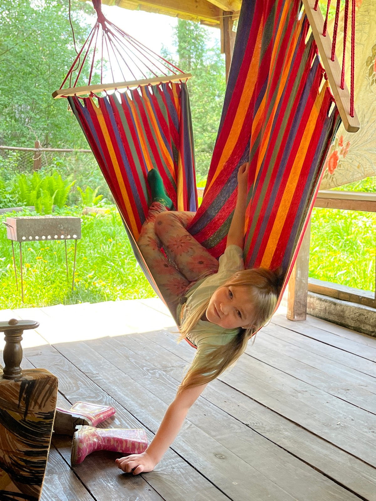 Child relaxes in striped hammock in Chaikovsky, Russia
