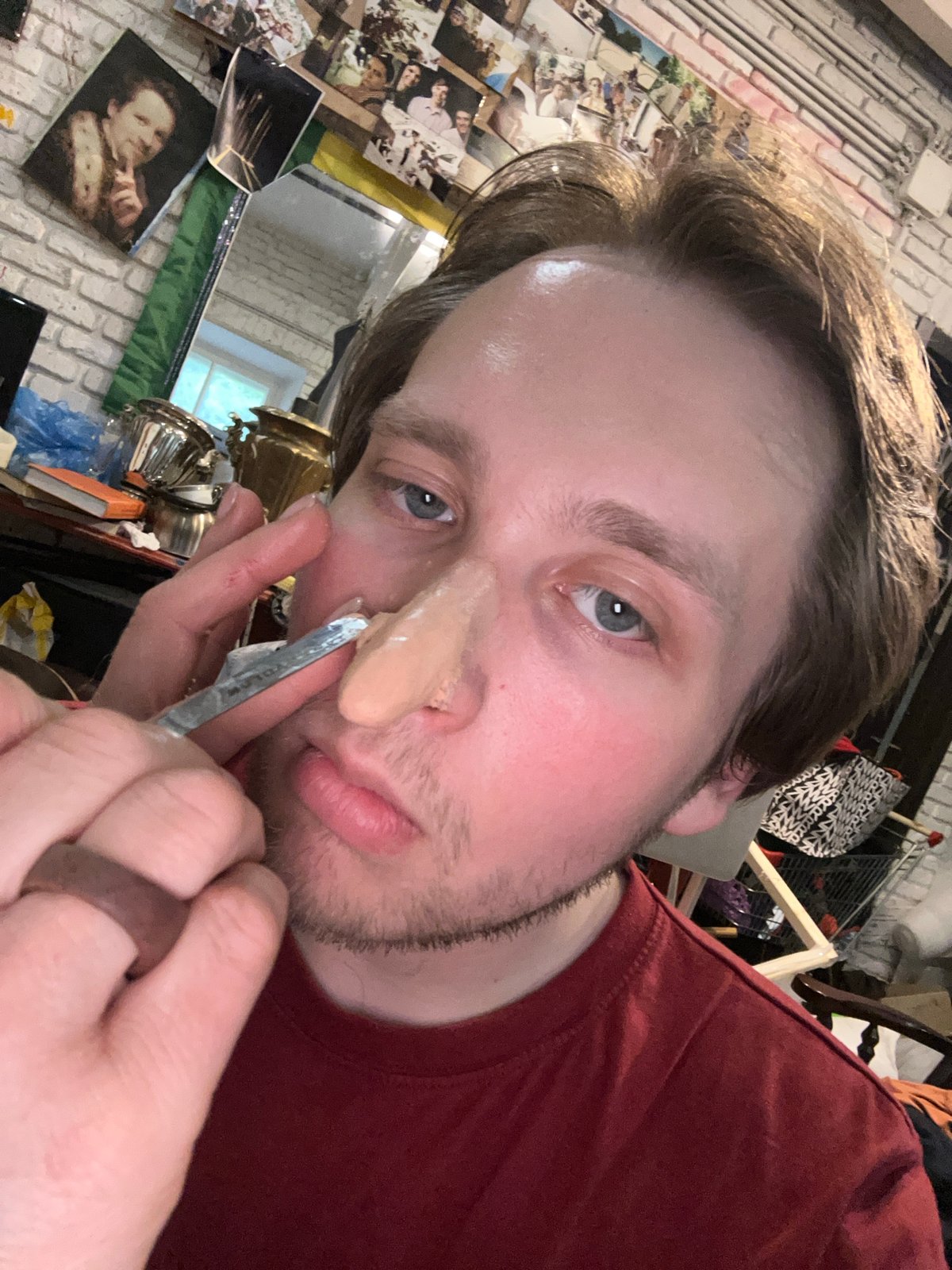 Person applies prosthetic nose makeup in multi-stage process