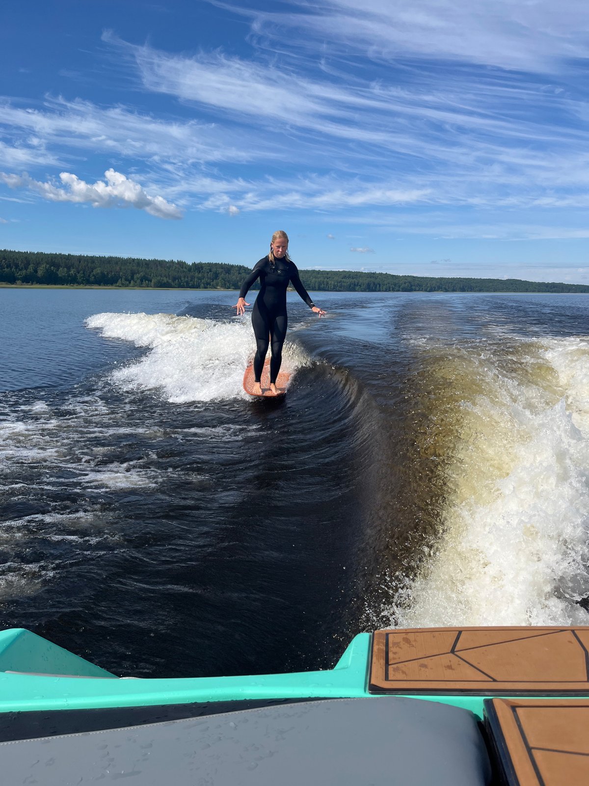 Wake surfing a calm Russian lake on a summer morning