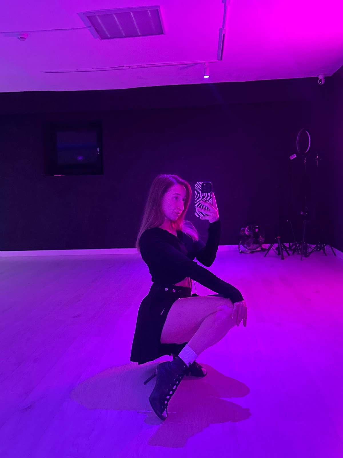 Woman poses for purple-lit selfie session in Chaikovsky