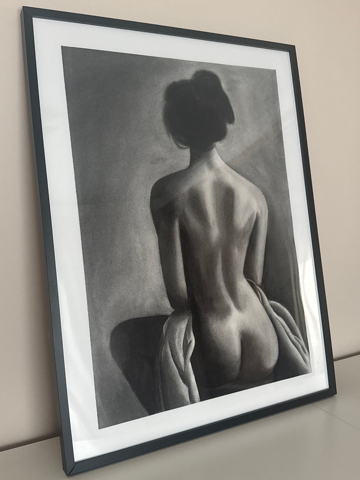 Charcoal nude drawing observed on wall display