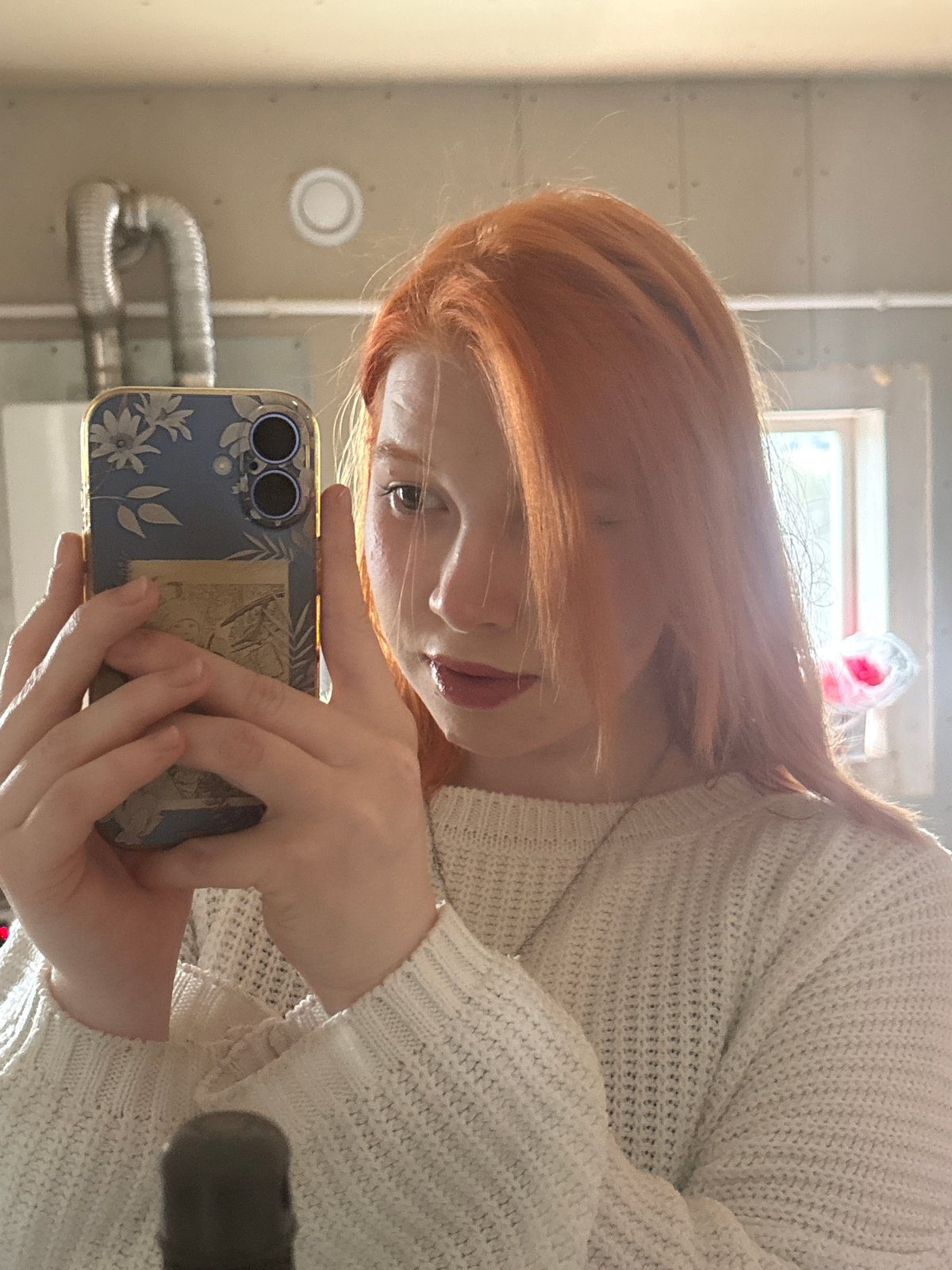 Red-haired person takes selfies in construction room