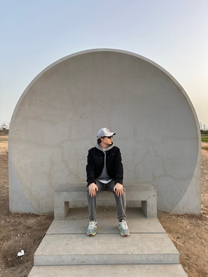 Person sits on steps inside dome structure in Tel Aviv