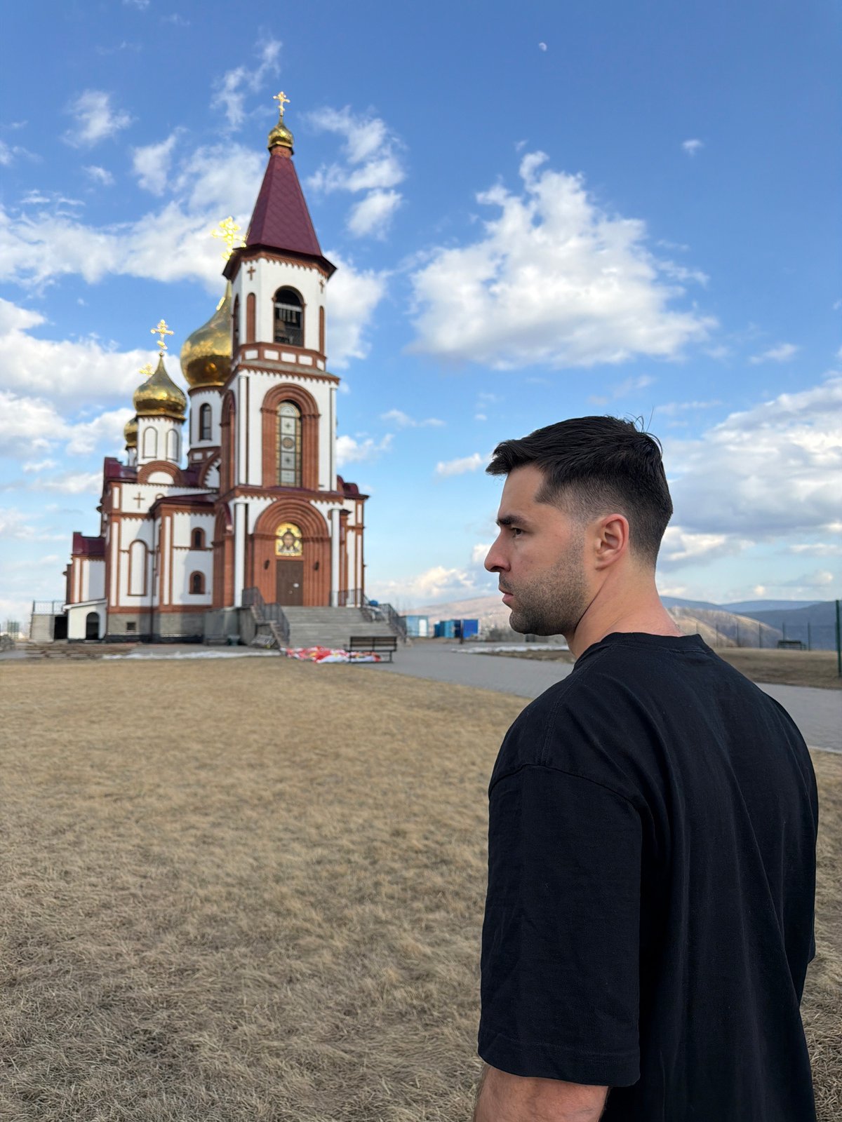 Man mimics Christ statue pose at Krasnoyarsk chapel