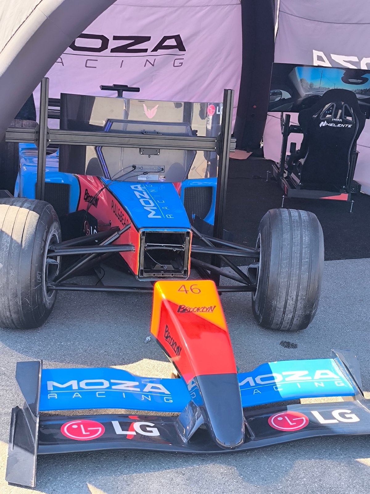 Damaged race car photographed under tent in Riga