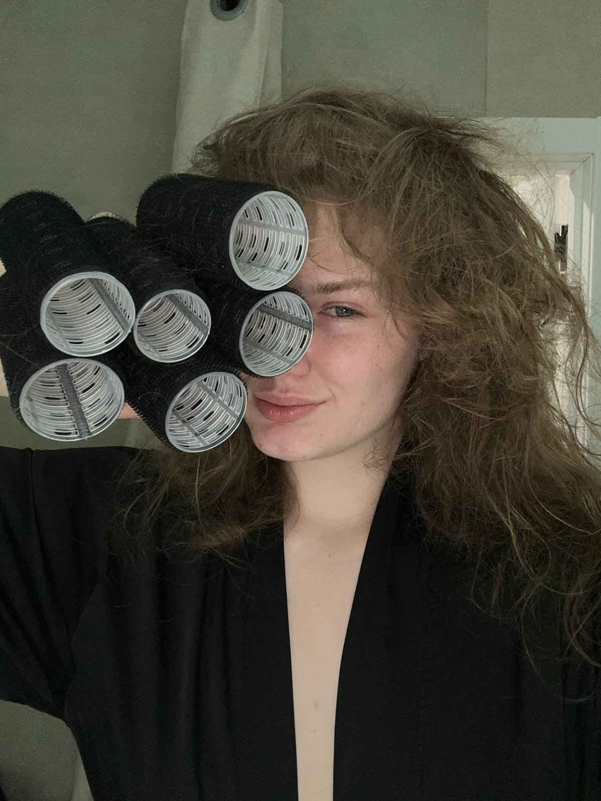 Woman uses hair rollers during beauty routine in Kazan