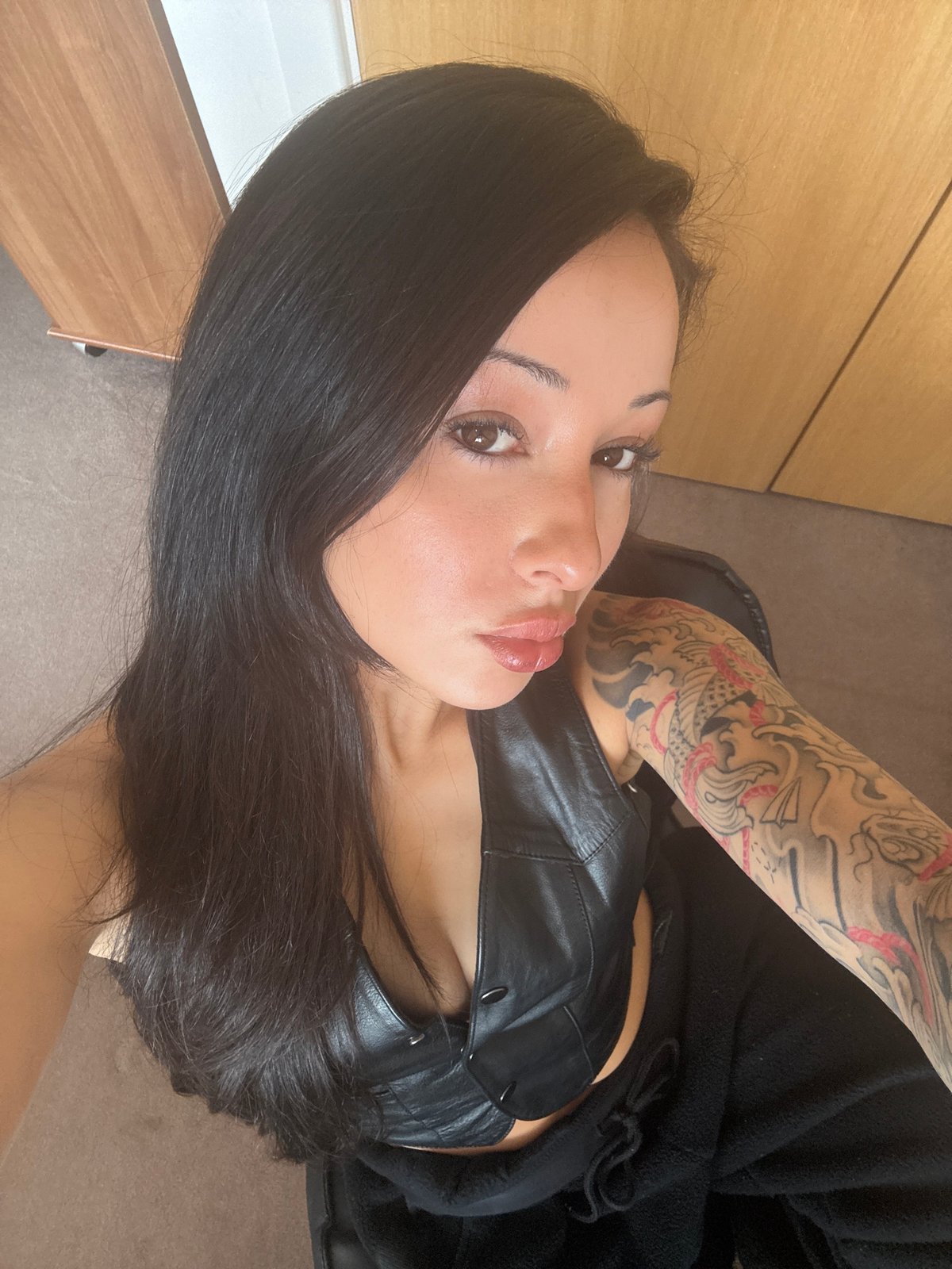 Woman takes selfies in black leather top in London