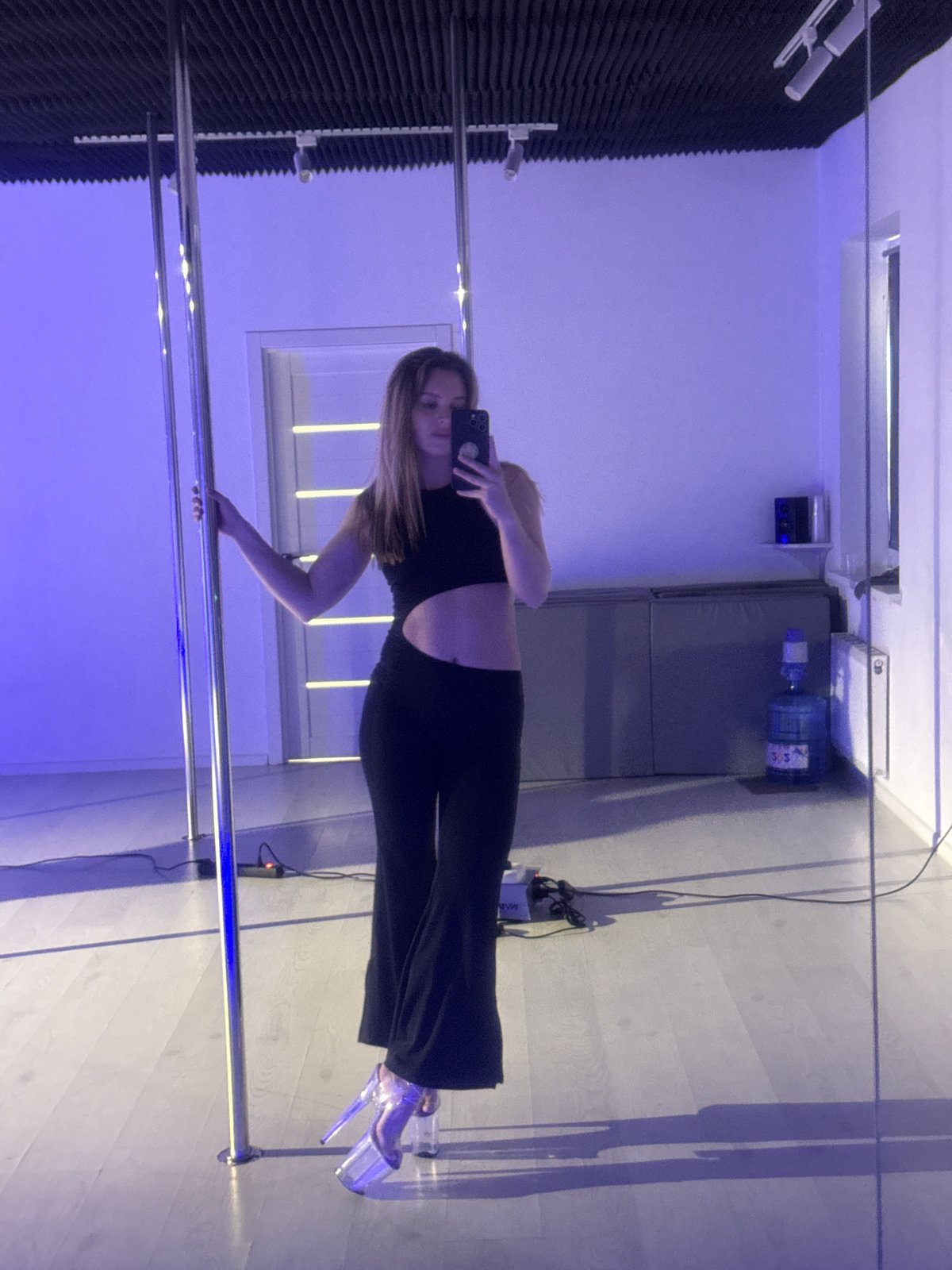 Woman takes selfie in room with dance pole in Hrodna