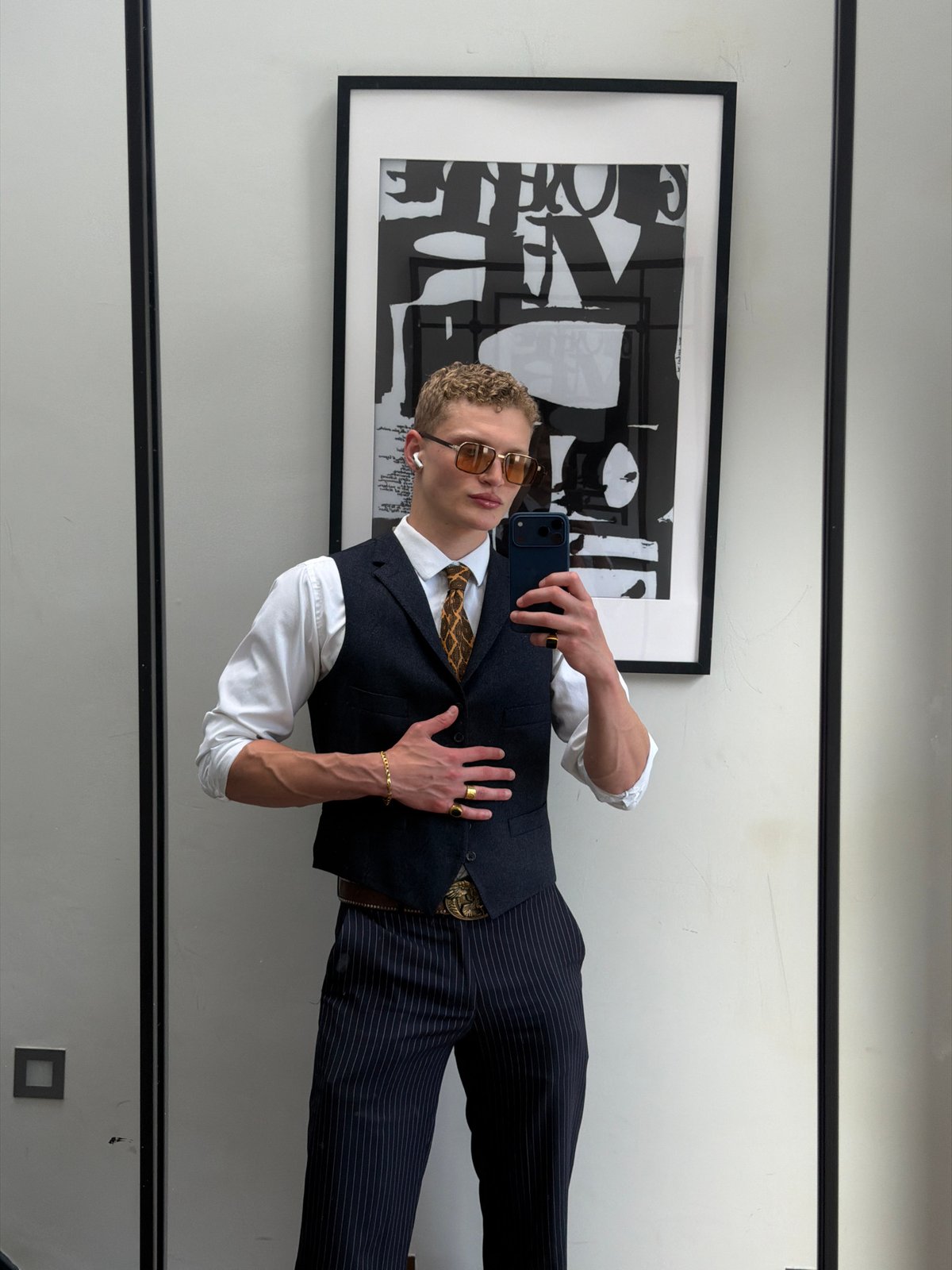 Mirror selfie in a London room with abstract art backdrop
