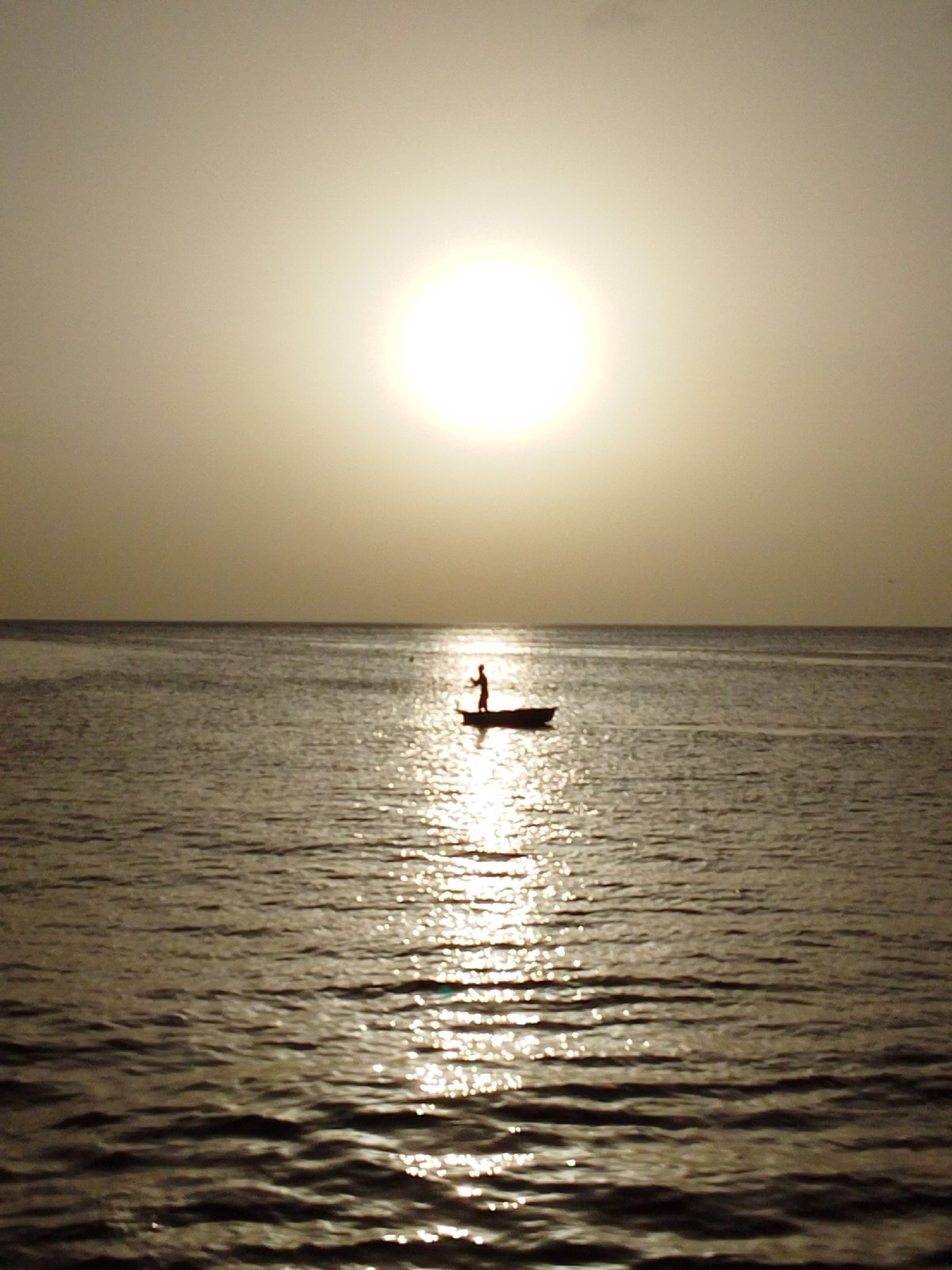Quiet coastal sunset: boats, shoreline, and golden-hour calm
