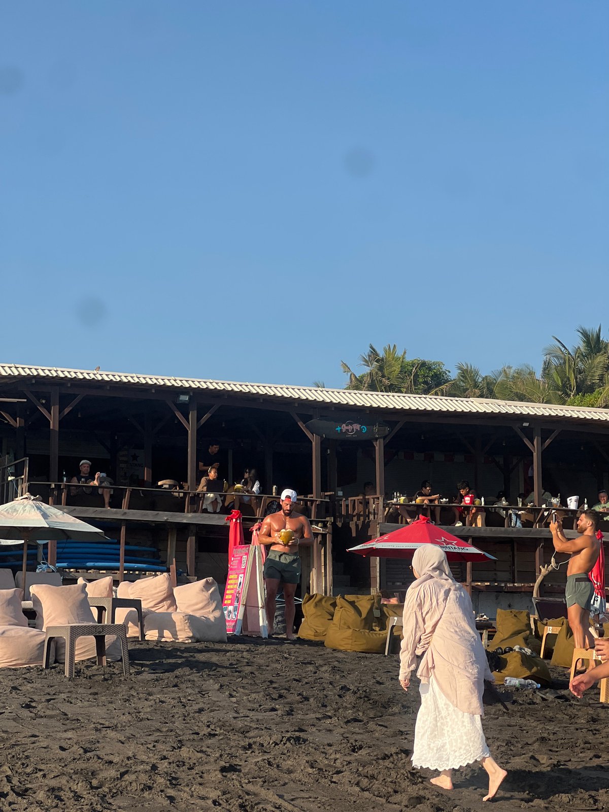 Morning beach life along North Kuta's dark sand shores