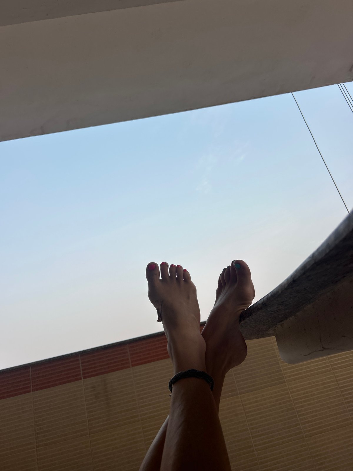 Low-angle photos capture feet and architecture in Puttaparthi