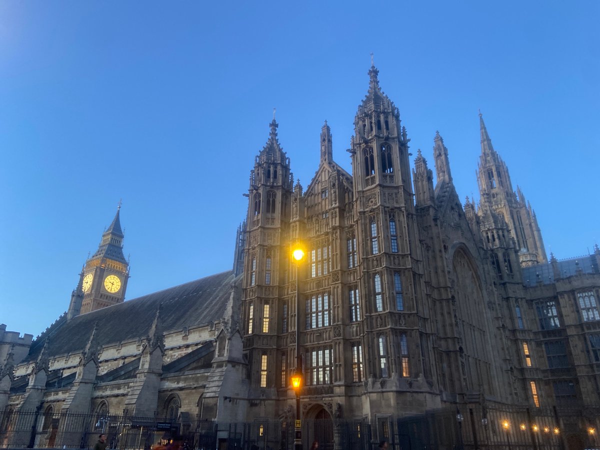 Tourist documents Westminster landmarks during London evening twilight