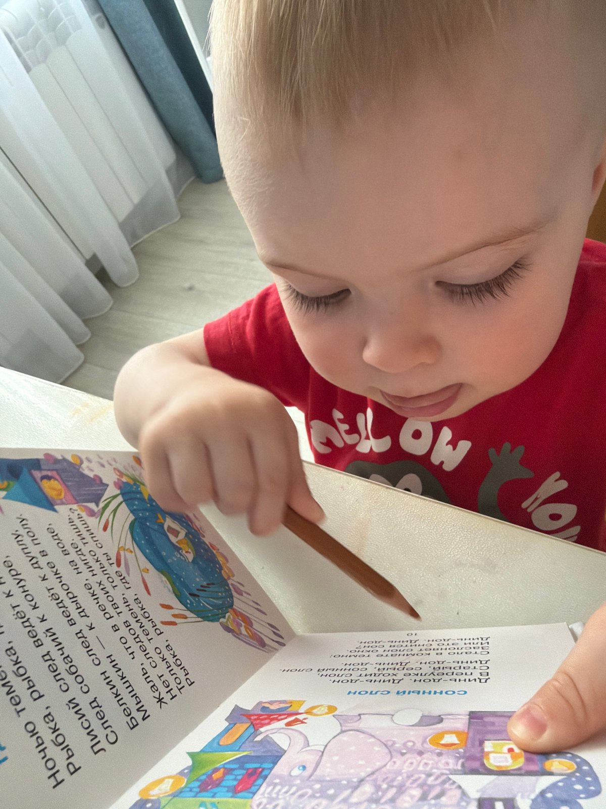 Child draws and reads with colored pencils in Votkinsk